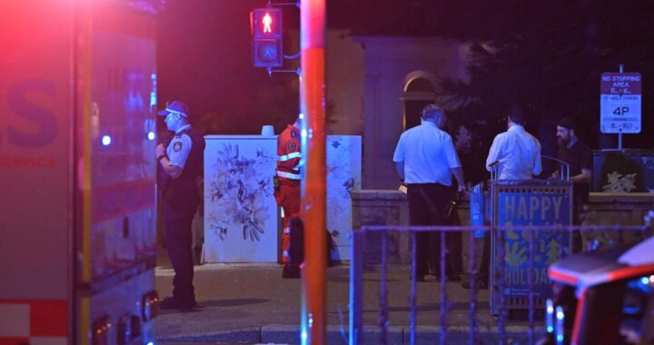 Vehículos de emergencia y personal de seguridad en una escena nocturna con luces de advertencia activadas.