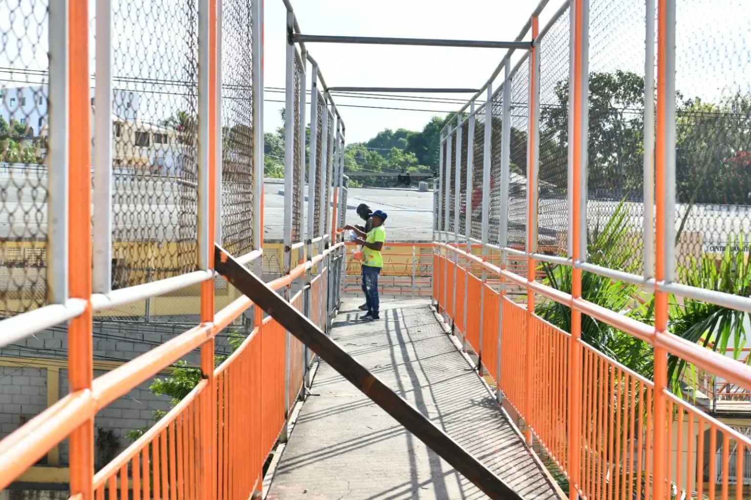 Autoridades reparan puente peatonal con malla colapsada en Santiago.